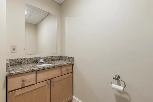 a bathroom with a granite countertop sink and vanity