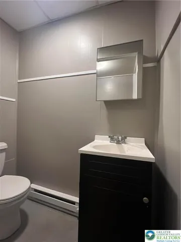 a bathroom with a sink a toilet and mirror