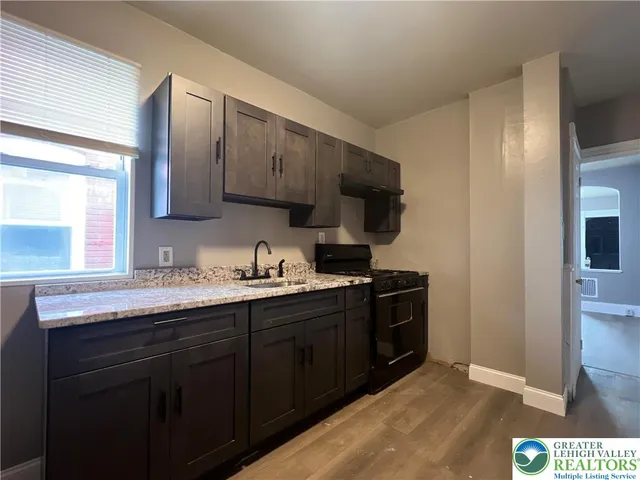 a kitchen with stainless steel appliances granite countertop a stove a sink and a refrigerator