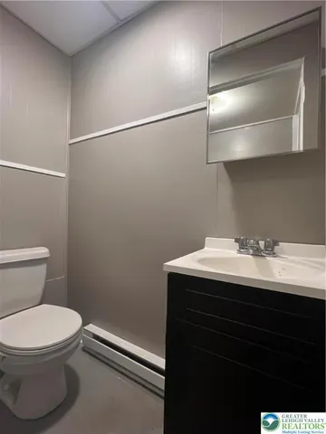 a bathroom with a sink a toilet and mirror