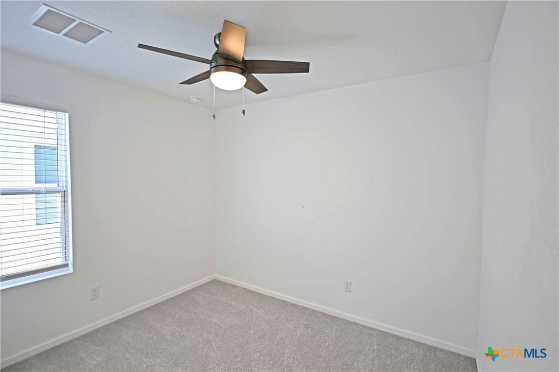 11822 Bluebell Ridge Converse, TX 78109 - Photo 18 of 24 an empty room with a window and a fan