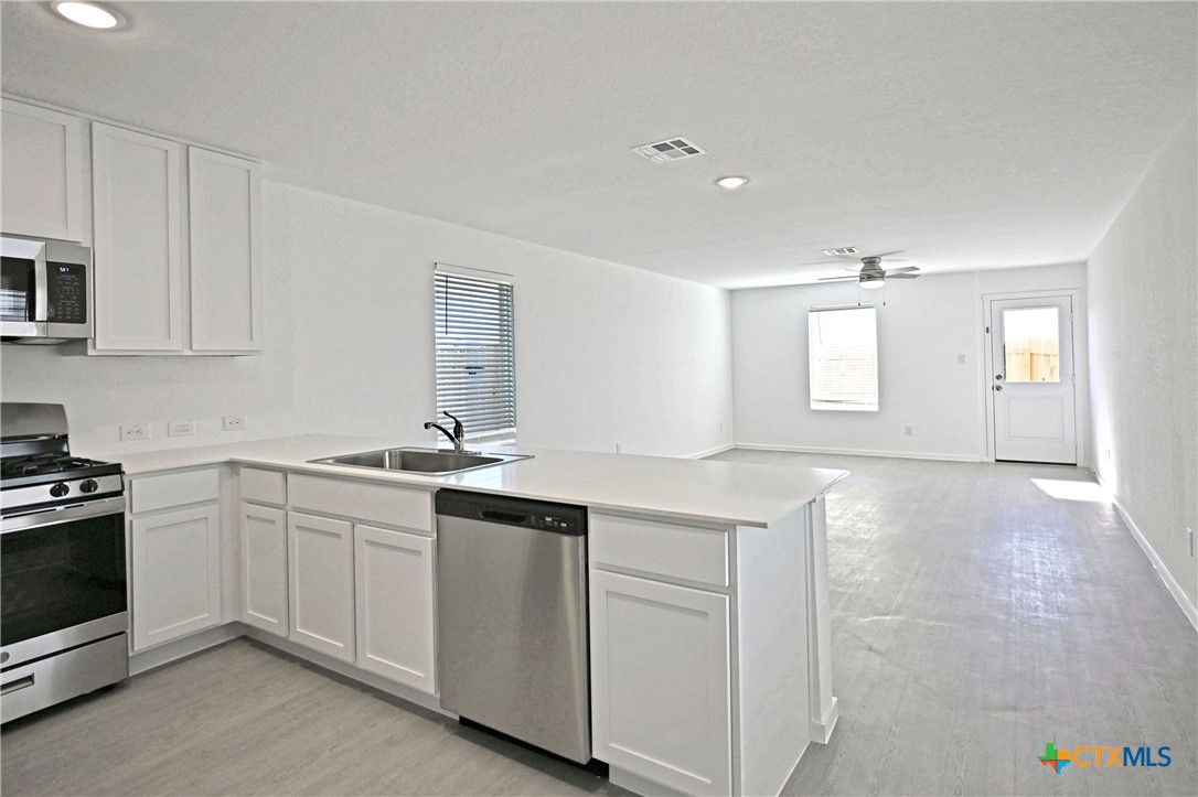 11822 Bluebell Ridge Converse, TX 78109 - Photo 4 of 24 a kitchen with white cabinets and sink