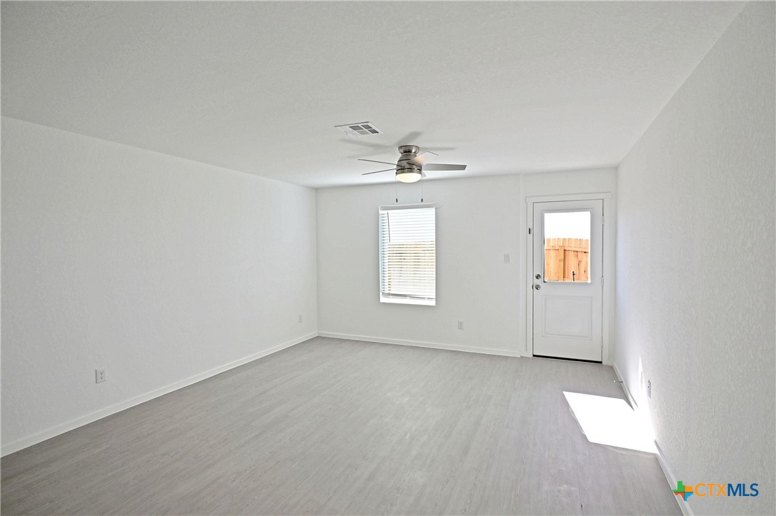 11822 Bluebell Ridge Converse, TX 78109 - Photo 6 of 24 an empty room with a ceiling fan and window