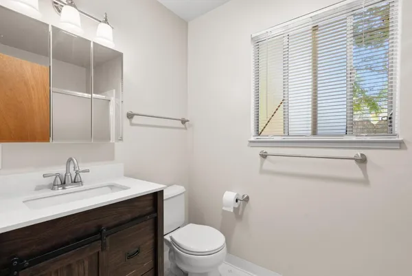 a bathroom with a sink a toilet and a window