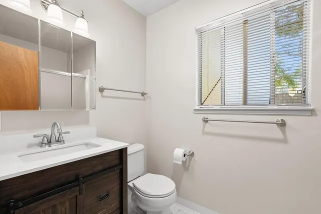 a bathroom with a sink a toilet and a window
