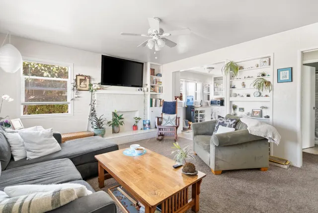 a living room with furniture a flat screen tv and a large window