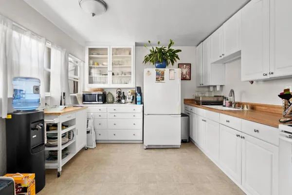 a kitchen with white cabinets and white appliances