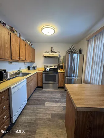 a large kitchen with stainless steel appliances granite countertop a stove a sink dishwasher and a refrigerator