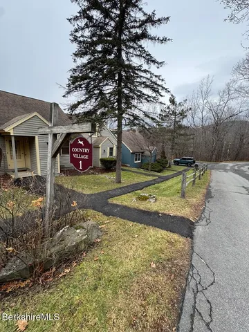 a view of a tennis ground with large trees