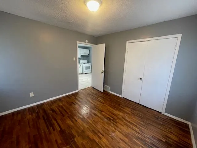 a view of empty room with wooden floor