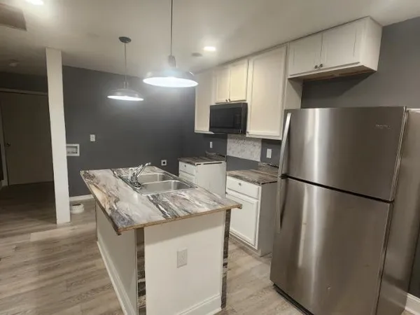 a kitchen with stainless steel appliances granite countertop a refrigerator a sink and a stove