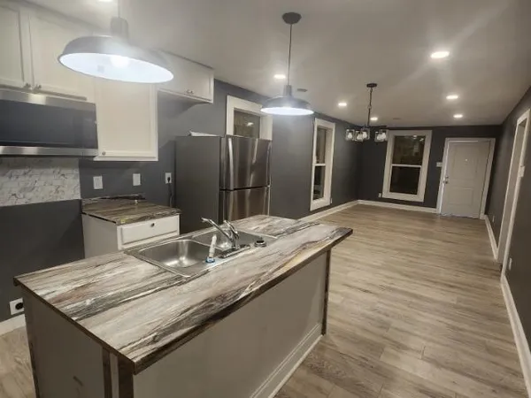 a kitchen with stainless steel appliances granite countertop a sink and a refrigerator