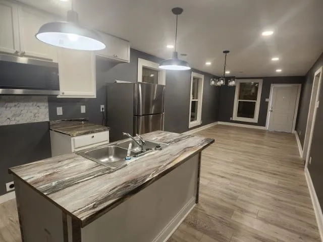 a kitchen with stainless steel appliances granite countertop a sink and a refrigerator