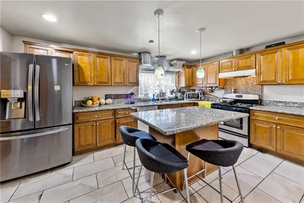 a kitchen with granite countertop wooden cabinets and stainless steel appliances