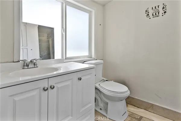 a bathroom with a sink mirror vanity and toilet