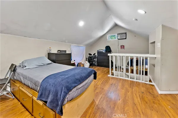 a spacious bedroom with a bed and a wooden floor