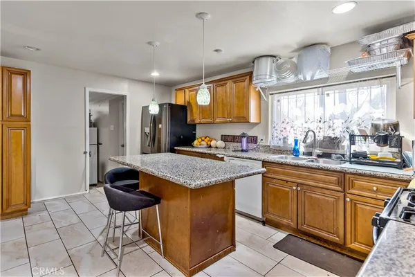 a kitchen with stainless steel appliances granite countertop a stove a sink and a refrigerator