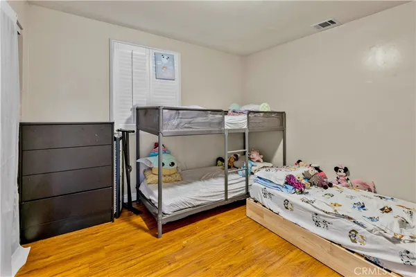 a bedroom with a bed and wooden floor