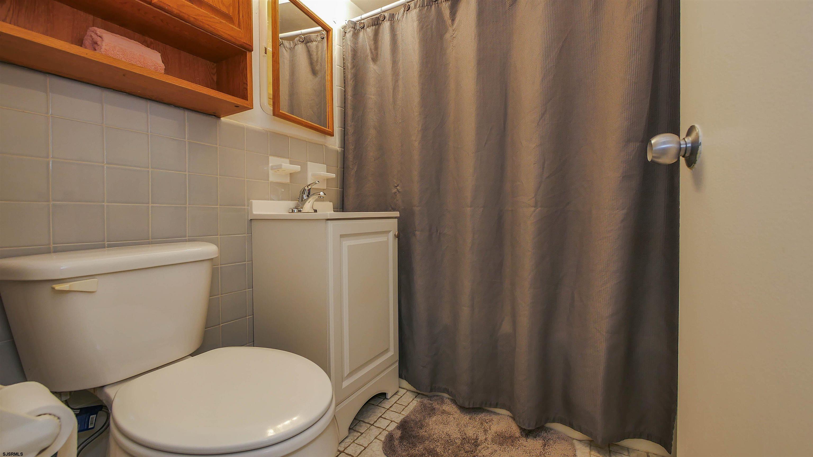 101 South Raleigh Avenue, Unit 207 Atlantic City, NJ 08401 - Photo 17 of 30 a white toilet sitting next to a shower curtain