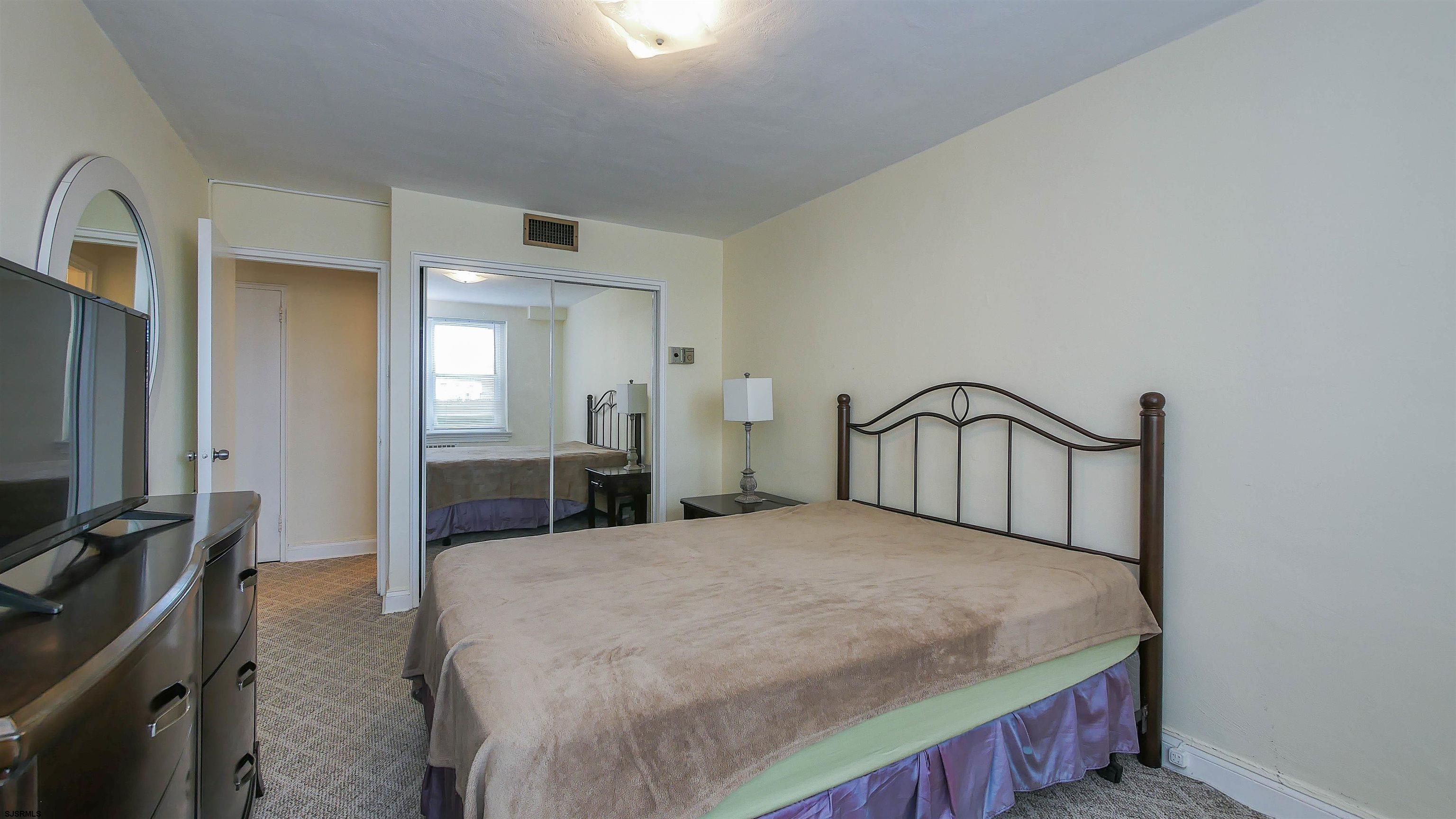 101 South Raleigh Avenue, Unit 207 Atlantic City, NJ 08401 - Photo 20 of 30 a bedroom with a bed and a flat tv screen on the dresser