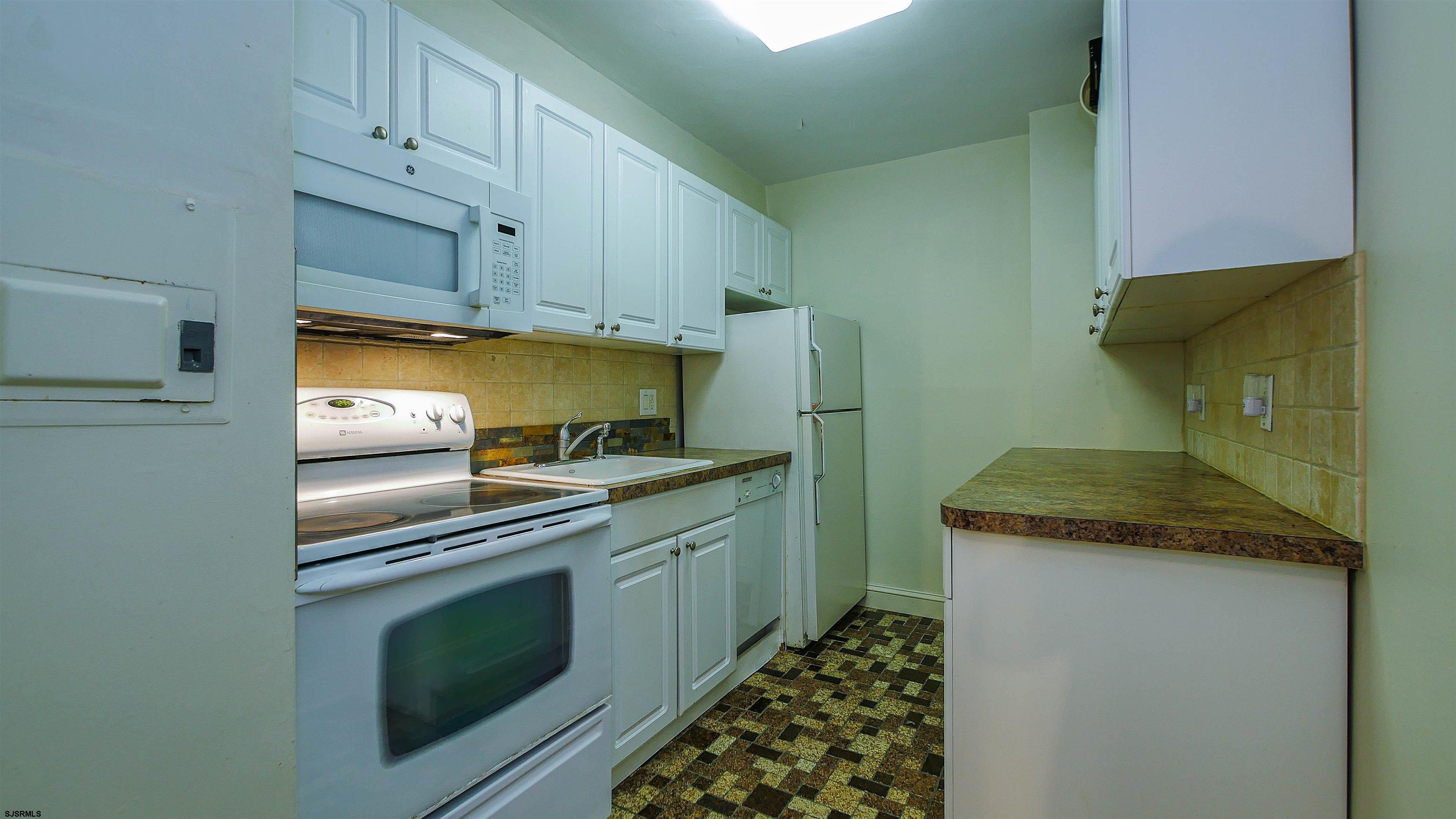 101 South Raleigh Avenue, Unit 207 Atlantic City, NJ 08401 - Photo 8 of 30 a kitchen with granite countertop a sink and a stove top oven