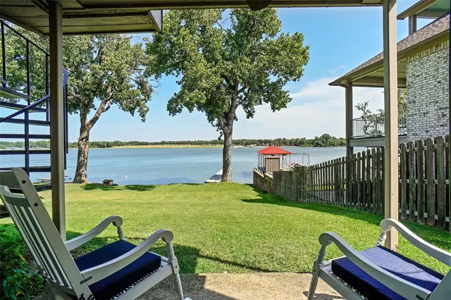 a view of a patio with lawn chairs floor to ceiling window and lake view