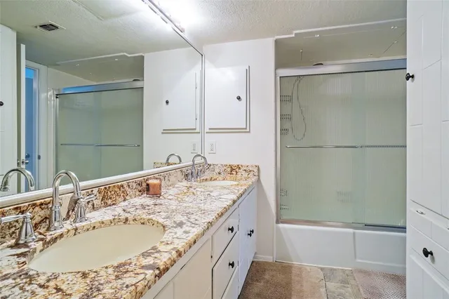 a bathroom with a granite countertop sink mirror and toilet