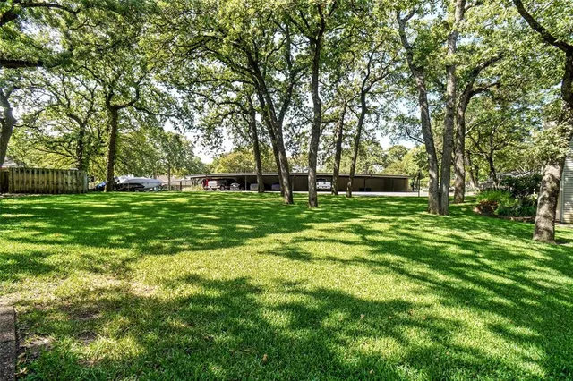 an aerial view of a house with a yard and lake view