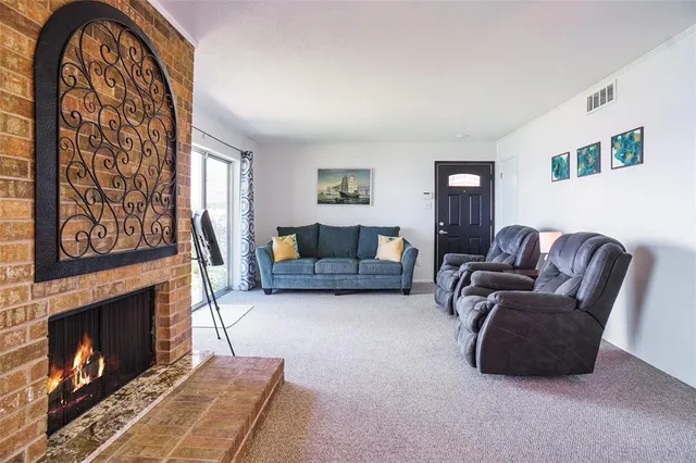 a living room with furniture a fireplace and a large window