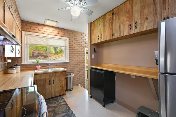 a kitchen with stainless steel appliances granite countertop a sink a stove cabinets counter space and a window