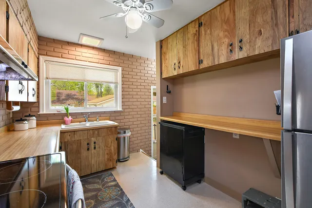 a kitchen with stainless steel appliances granite countertop a sink a stove cabinets counter space and a window