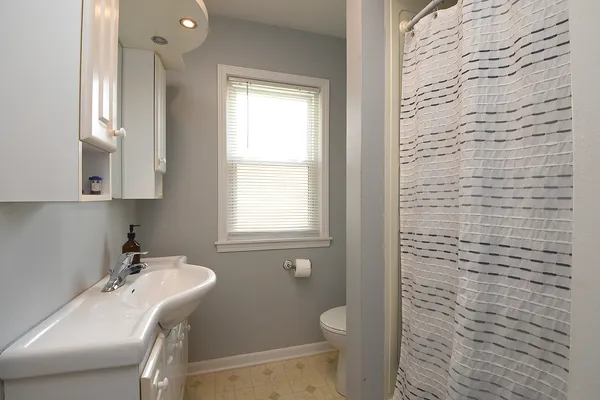 a bathroom with a sink a toilet and a window