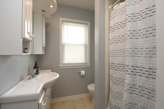 a bathroom with a sink a toilet and a window