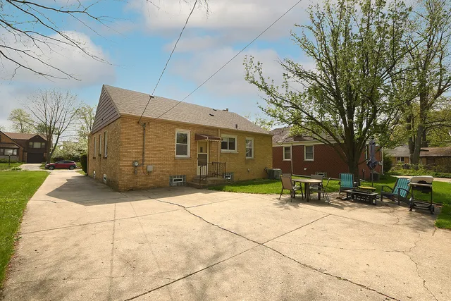 a patio with a table and chairs and potted plants