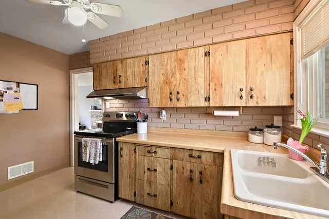 a kitchen with stainless steel appliances granite countertop a sink a stove and cabinets