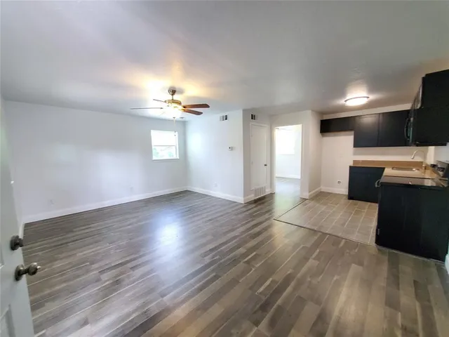 a view of a kitchen with a sink a stove top oven and cabinets
