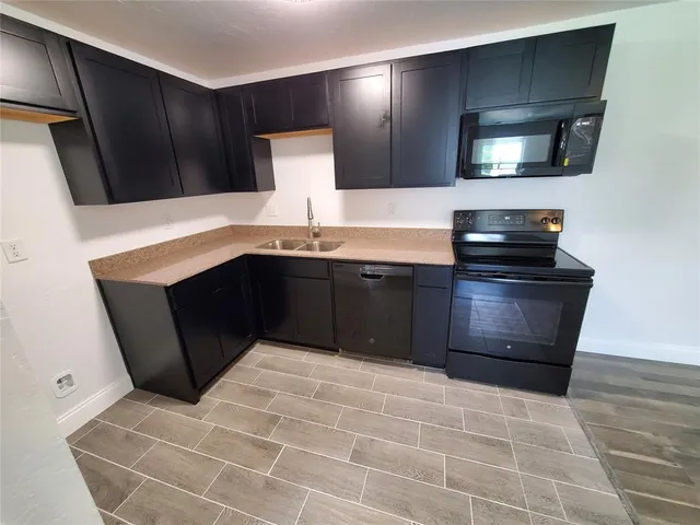 a kitchen with stainless steel appliances a sink stove and microwave