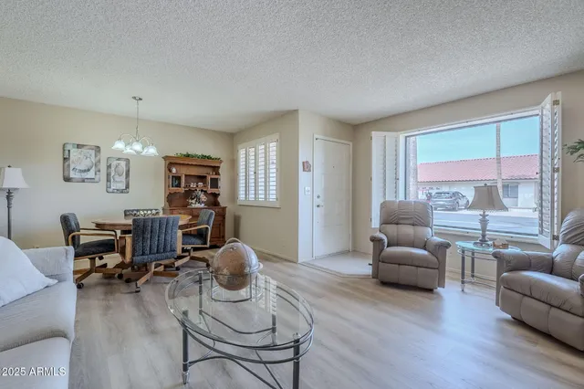 a living room with furniture a dining table and a window