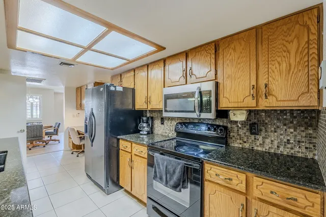 a kitchen with stainless steel appliances granite countertop a refrigerator stove and sink