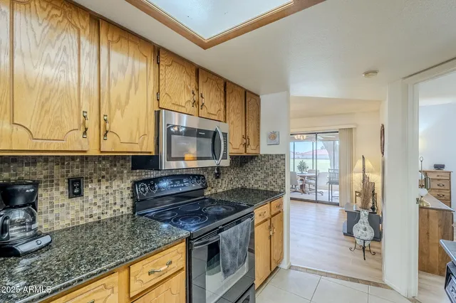 a kitchen with stainless steel appliances granite countertop a stove a sink and a microwave