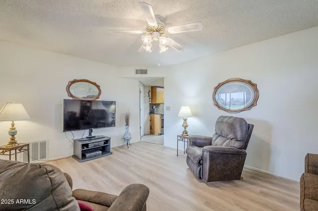 a living room with furniture a mirror and a flat screen tv