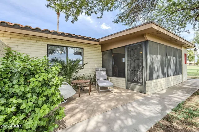 a view of a chair and table in the backyard of the house