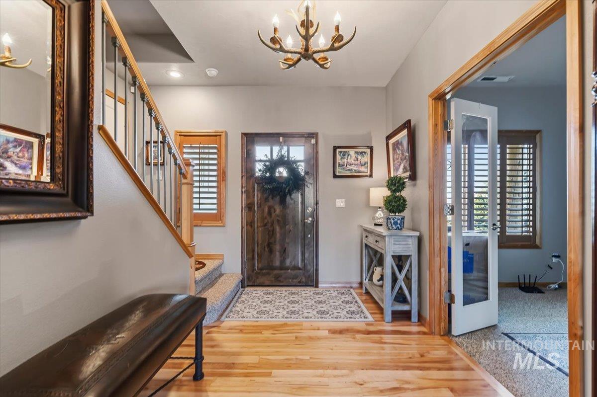 11660 Timber Butte Road Sweet, ID 83670 - Photo 4 of 49 Wood-finish flooring, staircase with wrought iron balusters, and a solid wood entry door with glass panes