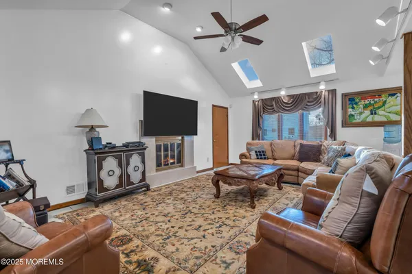 a living room with furniture a flat screen tv and kitchen view