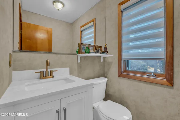 a bathroom with a toilet sink and mirror
