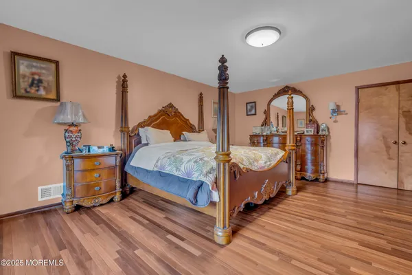 a bedroom with a bed and wooden floor