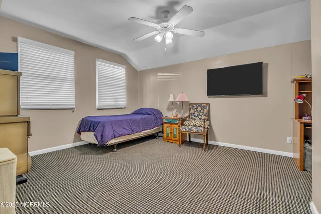 a spacious bedroom with a bed and a flat screen tv