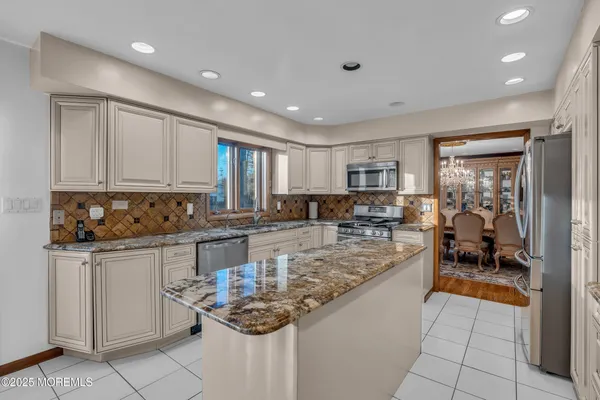 a large kitchen with stainless steel appliances granite countertop a stove and a sink