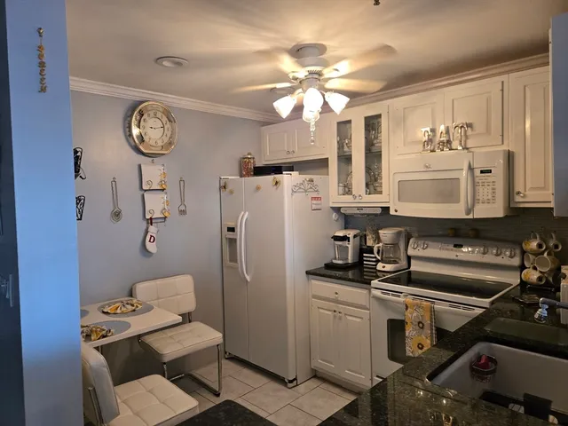 a kitchen with appliances a sink and cabinets