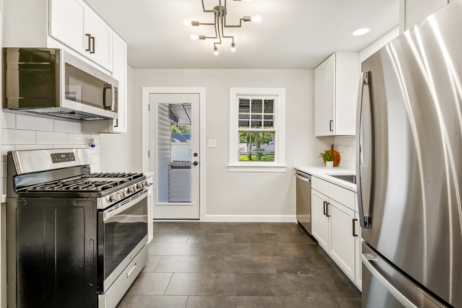 18540 Miller Drive Lansing, IL 60438 - Photo 19 of 57 a kitchen with stainless steel appliances granite countertop a stove a sink and a refrigerator